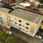 Fachada do GAAC (Grupo de Apoio e Amparo à Criança) em Manaus, com carros estacionados.