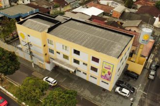 Fachada do GAAC (Grupo de Apoio e Amparo à Criança) em Manaus, com carros estacionados.