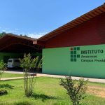 Fachada do Instituto Federal do Amazonas - Campus Presidente Figueiredo, com gramado e céu azul.