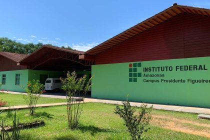 Fachada do Instituto Federal do Amazonas - Campus Presidente Figueiredo, com gramado e céu azul.