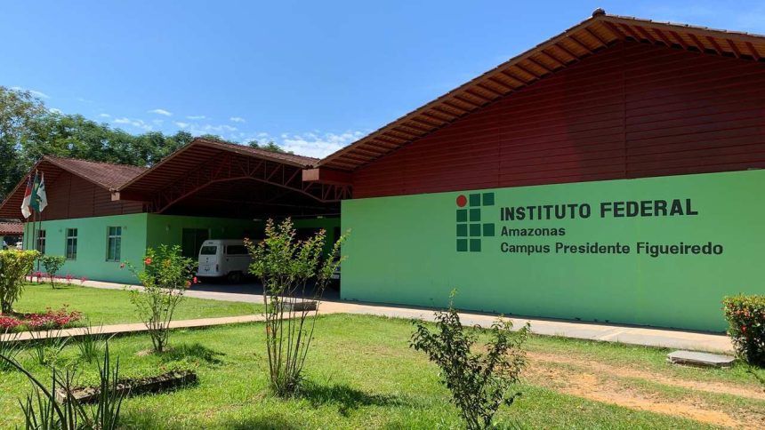 Fachada do Instituto Federal do Amazonas - Campus Presidente Figueiredo, com gramado e céu azul.