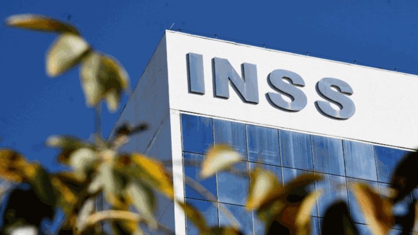 Fachada do prédio do INSS com o logotipo em destaque e folhagens em primeiro plano.