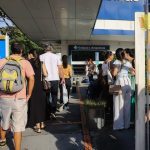 Fila de pessoas em frente à entrada da Estácio Amazonas, com avisos de salas e blocos.