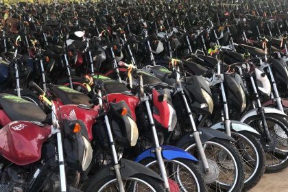 Grande quantidade de motos estacionadas em pátio, diversas cores e modelos.