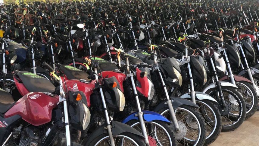 Grande quantidade de motos estacionadas em pátio, diversas cores e modelos.