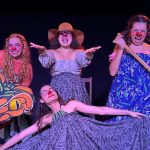 Grupo de atrizes caracterizadas como palhaças em apresentação teatral sobre lendas amazônicas.