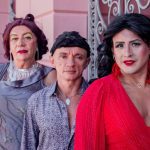 Grupo de pessoas caracterizadas em trajes, possivelmente drag queens, posam para foto.