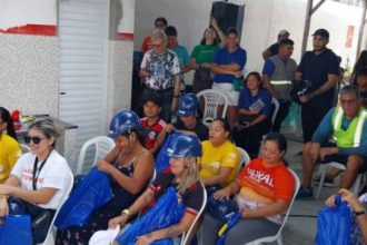 Grupo de pessoas em evento, usando capacetes azuis e camisetas na Virada Sustentável