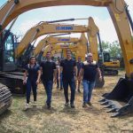 Grupo de pessoas com Sidney Leite em frente a várias escavadeiras XCMG.