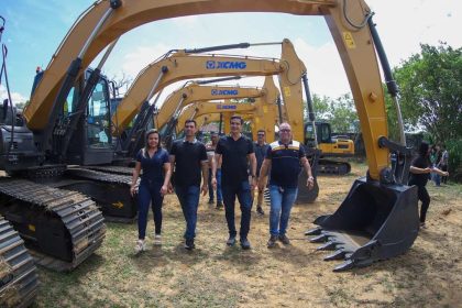 Grupo de pessoas com Sidney Leite em frente a várias escavadeiras XCMG.