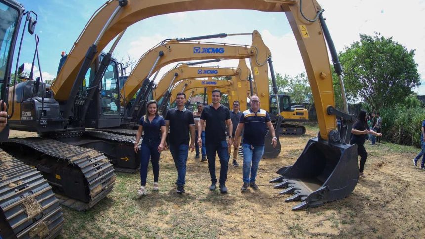Grupo de pessoas com Sidney Leite em frente a várias escavadeiras XCMG.