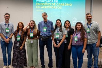 Grupo de pessoas em workshop sobre emissões de carbono em aeroportos no Aeroporto de Manaus.
