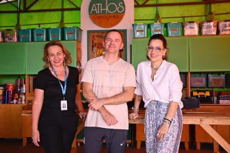 Grupo posa em frente ao logotipo da ATHOS Cenografia.