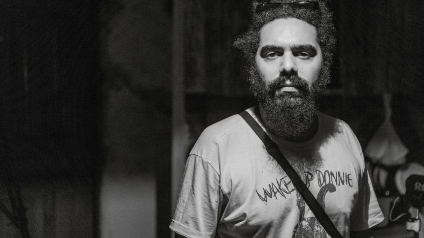 André Cunha ‘Mata-gato’ Homem barbudo com camiseta 'Wake Up Donnie' em preto e branco