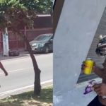Homem carrega jacaré nos ombros enquanto caminha na rua. Cena inusitada com animal exótico.