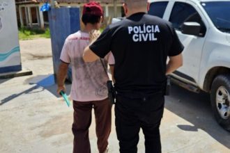 Homem preso por abuso sexual infantil sendo levado por policial.