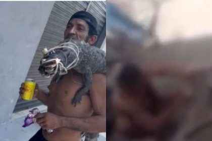 Homem segura jacaré morto nos ombros, com bebida na mão, cena de violência.