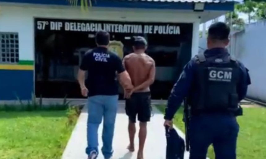 Homem sendo escoltado por policiais em frente à delegacia de polícia.