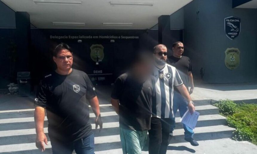 Homem suspeito de homicídio sendo escoltado pela polícia.