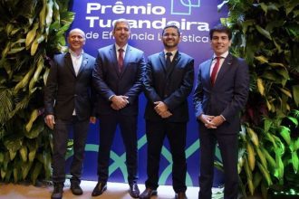 Homens em trajes formais posam para foto em evento de premiação.