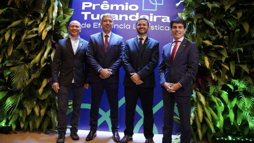 Homens em trajes formais posam para foto em evento de premiação.