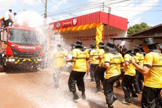 Inauguração de unidade do Corpo de Bombeiros em Autazes, com caminhão e bombeiros sendo molhados.