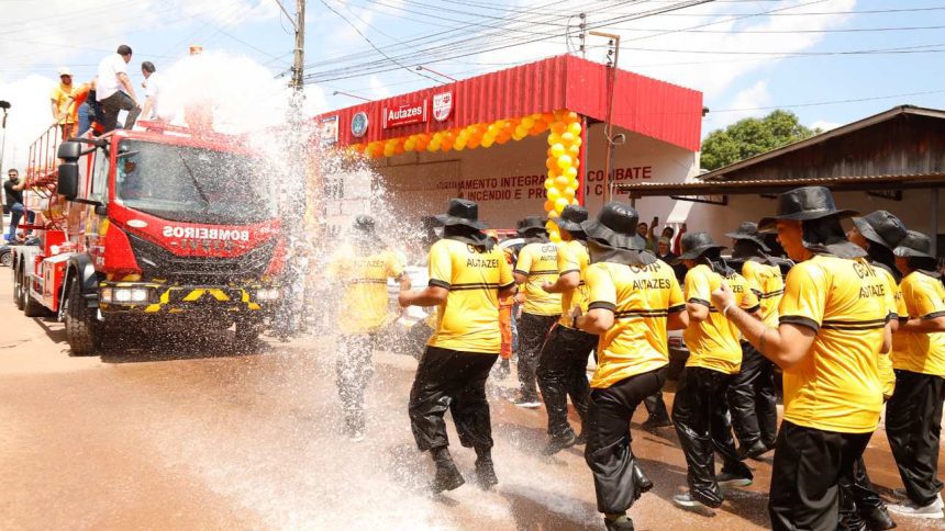 Inauguração de unidade do Corpo de Bombeiros em Autazes, com caminhão e bombeiros sendo molhados.