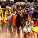Indígenas da etnia Sururuá reunidos, com pinturas corporais e vestimentas tradicionais, em celebração.