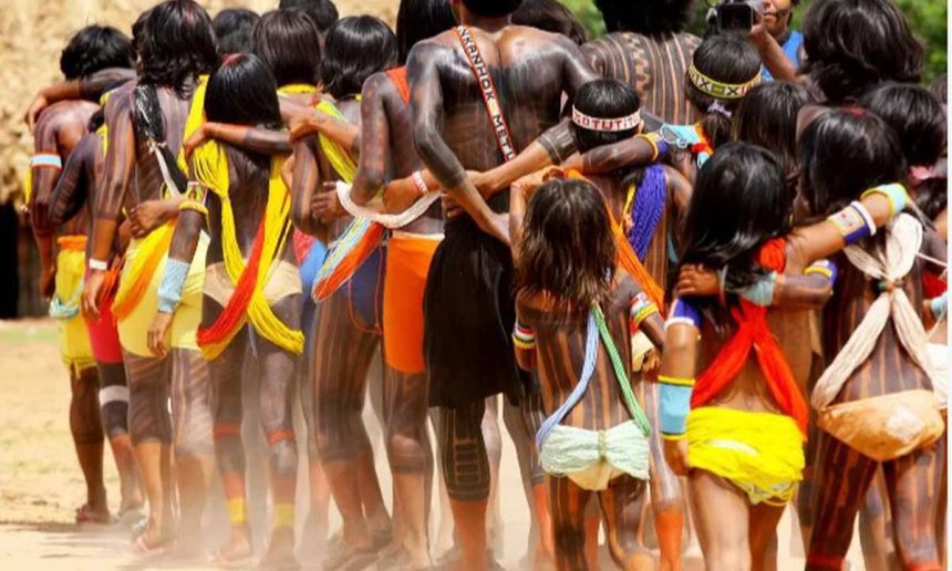 Indígenas da etnia Sururuá reunidos, com pinturas corporais e vestimentas tradicionais, em celebração.