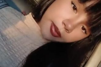 Jovem com cabelo preto e batom escuro em foto