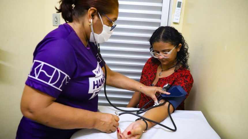 Médica aferindo pressão arterial em paciente durante consulta em Manaus