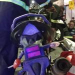 Motocicleta sendo removida por bombeiros após acidente, com cones de sinalização e pessoas no local.
