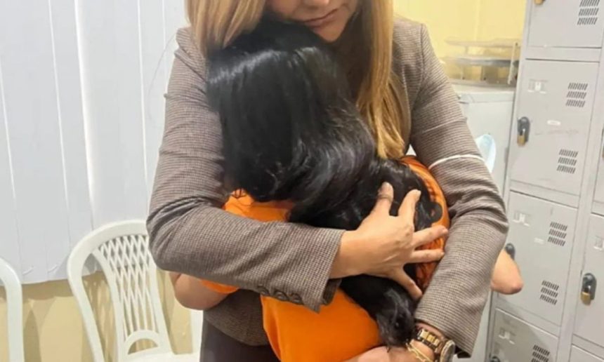 Mulher abraçando outra em um ambiente interno