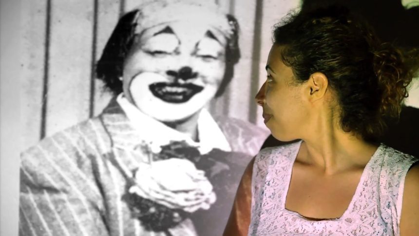 Mulher olhando para projeção de um palhaço em filme antigo