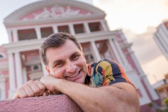 Nícolas Jr. sorrindo em frente ao Teatro Amazonas, em Manaus