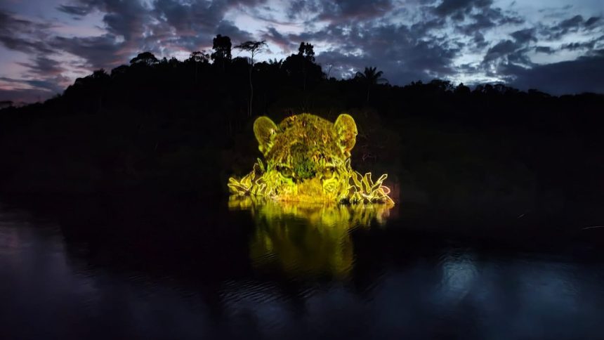 Obra de arte com projeção de onça em lago amazônico à noite.