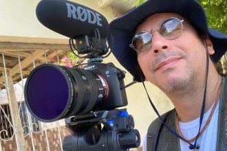 Orlando Júnior com câmera filmadora e microfone, pronto para oficina.