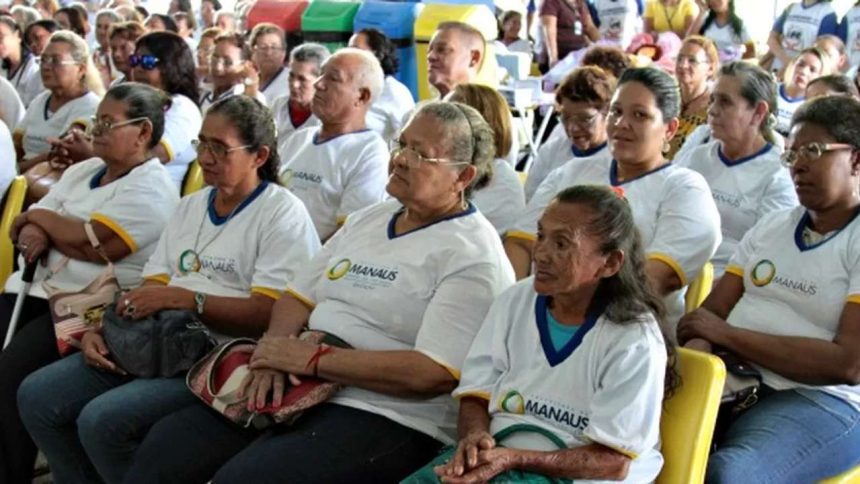Pessoas em evento educacional, com foco em mulheres com óculos e camisetas com logo da Prefeitura de Manaus.