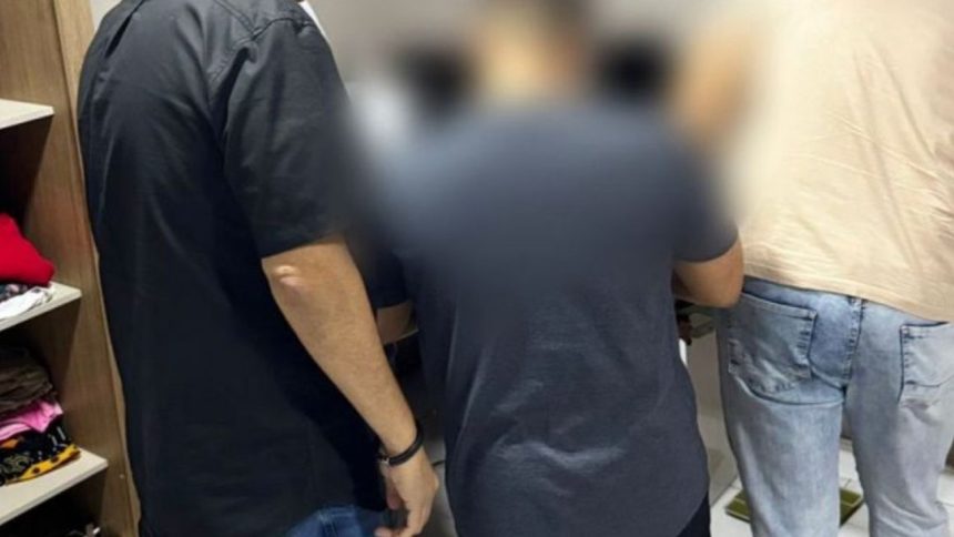 Pessoas em pé em uma sala, algumas com roupas escuras, outras com roupas claras.
