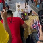 Pessoas fotografando um cão em um evento Pet.