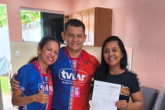 Pessoas sorrindo segurando comprovante da TVLAR em campanha de carro zero.