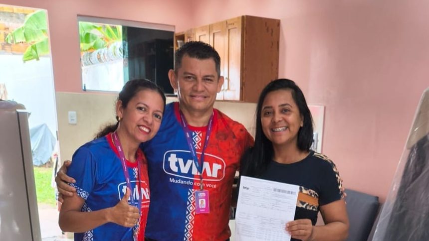 Pessoas sorrindo segurando comprovante da TVLAR em campanha de carro zero.