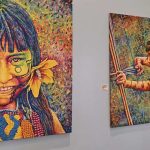 Pinturas vibrantes de indÃgenas amazônicos, em exposição artÃstica.
