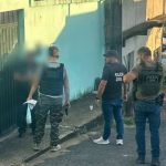 Polícia Civil em ação de investigação, com policiais em frente a uma residência.