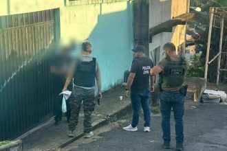 Polícia Civil em ação de investigação, com policiais em frente a uma residência.