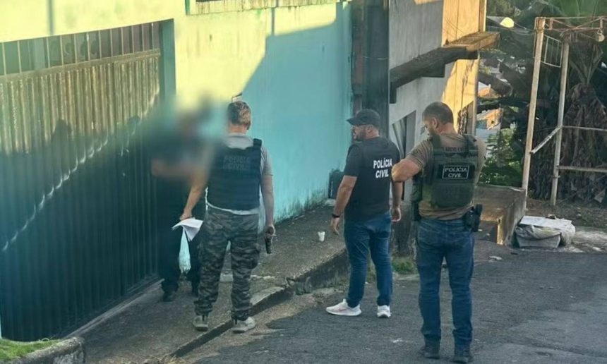 Polícia Civil em ação de investigação, com policiais em frente a uma residência.