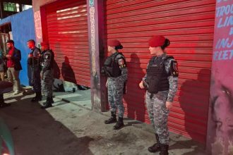 Policiais em frente a oficina mecânica, cena de crime.