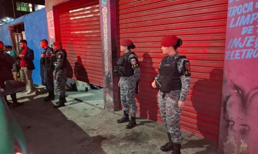 Policiais em frente a oficina mecânica, cena de crime.