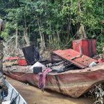 Policiais Federais em ação contra garimpo ilegal em rio da Amazônia. Embarcação destruída.