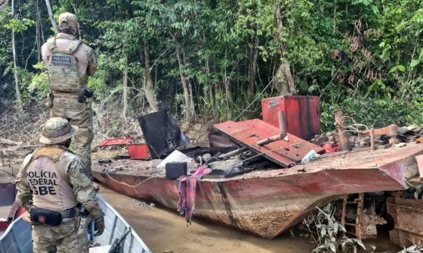 Policiais Federais em ação contra garimpo ilegal em rio da Amazônia. Embarcação destruída.